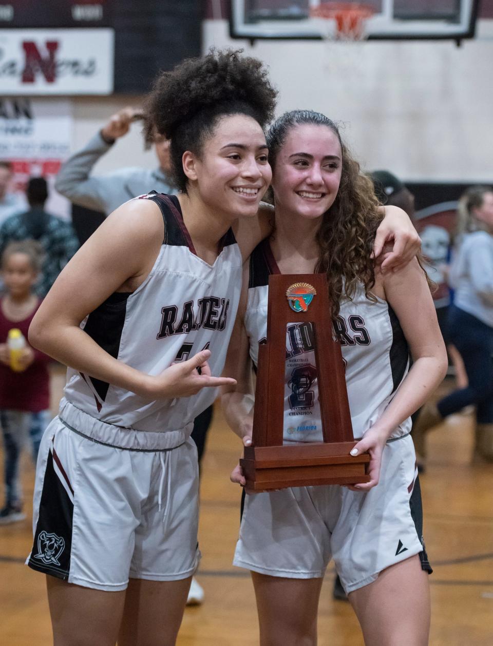 Rachel  Leggett (24) and Micheala Vollmer (23) pose with the trophy after their 52-42 victory in the Pace vs Navarre girls basketball District 1-6A championship game at Navarre High School in Navarre on Friday, Feb. 4, 2022.