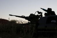 Tajammu Al-Ezza brigade fighters on an anti-aircraft weapon inspect the sky for helicopters loyal to Syria's president Bashar Al-Assad located in Hama countryside May 6, 2015. REUTERS/Mohamad Bayoush