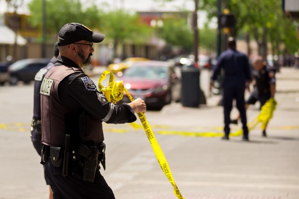 An El Paso police officer removes crime-scene tape used to block streets in Downtown during a death investigation on May 12. File art.