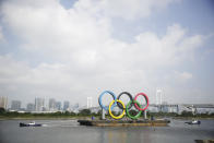 Tugboats move a symbol installed for the Olympic and Paralympic Games Tokyo 2020 on a barge moved away from its usual spot off the Odaiba Marine Park in Tokyo Thursday, Aug. 6, 2020. The five Olympic rings floating on a barge in Tokyo Bay were removed for what is being called “maintenance,” and officials says they will return to greet next year's Games. The Tokyo Olympics have been postponed for a year because of the coronavirus pandemic and are to open on July 23, 2021. The Paralympics follow on Aug. 24. (AP Photo/Hiro Komae)