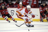 Calgary Flames center Tyler Pitlick (18) chases after the puck during the second period of an NHL hockey game against the New Jersey Devils Tuesday, Oct. 26, 2021, in Newark, N.J. (AP Photo/Bill Kostroun)