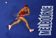 Maria Sharapova of Russia uses her left hand to hit a return against Petra Martic of Croatia during their women's singles first round match at the Australian Open 2015 tennis tournament in Melbourne January 19, 2015. REUTERS/Carlos Barria