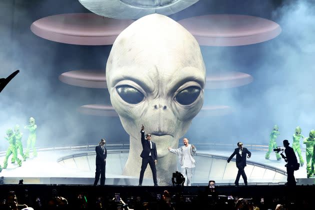 The pair danced in front of massive projections of alien heads. 