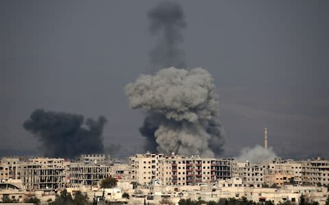 A picture taken on February 20 shows smoke plumes rising following a reported regime air strike in the rebel-held town of Hamouria, in the besieged Eastern Ghouta region - Credit: ABDULMONAM EASSA/AFP/Getty Images