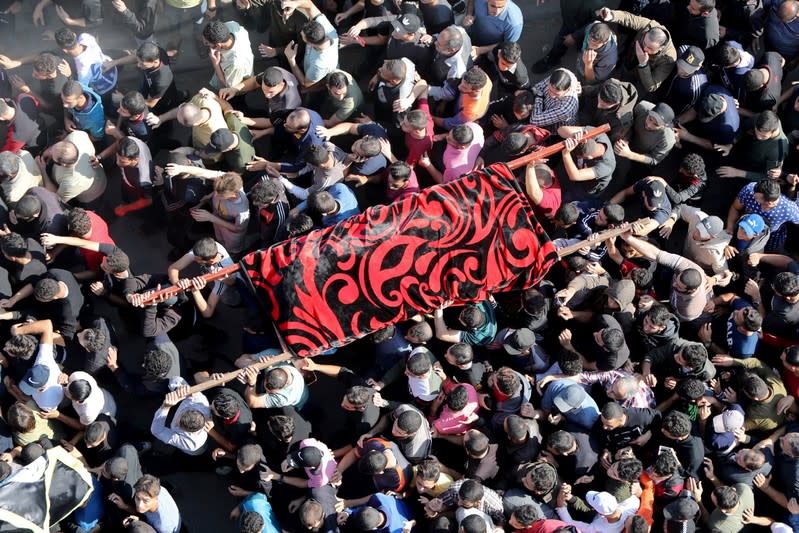 Mourners carry the body of the wife of Palestinian Islamic Jihad field commander Baha Abu Al-Atta during their funeral in Gaza City