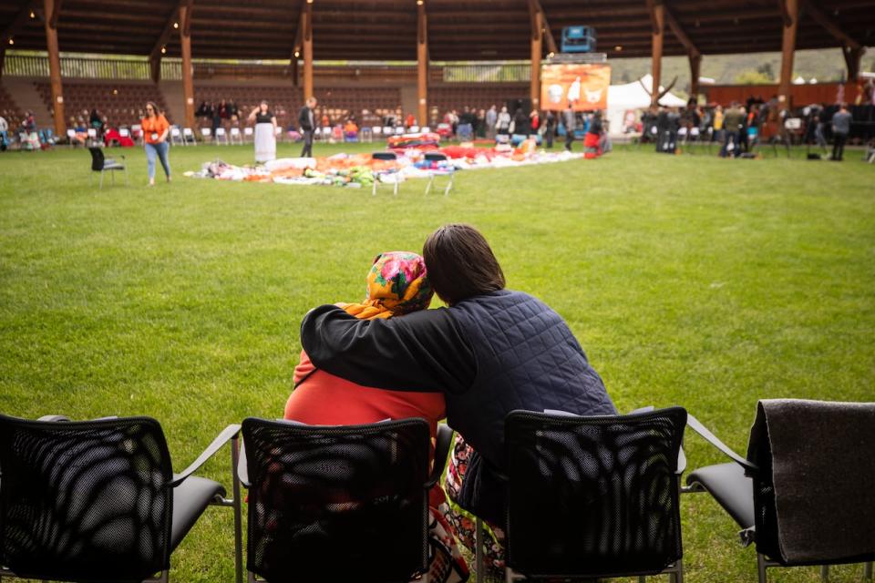 People gather in the arbour with the Tk'emlúps te Secwépemc First Nation to mark the one-year anniversary of the announcement of the discovery of potential burial sites at the former Kamloops Indian Residential School in Kamloops, B.C., on May 23, 2022. 