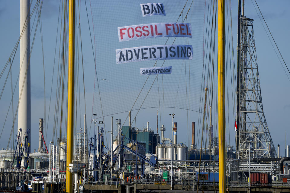 Greenpeace's Beluga II carries a banner reading "Ban Fossil Fuel Advertising" as it blocks part of the port at a Shell refinery in Rotterdam, Netherlands, Monday, Oct. 4, 2021. A coalition of environmental groups launched a campaign calling for a Europe-wide ban on fossil fuel advertising ahead of the United Nations Climate Change Conference, also known as COP26, which start in Glasgow on Oct. 31st, 2021. (AP Photo/Peter Dejong)