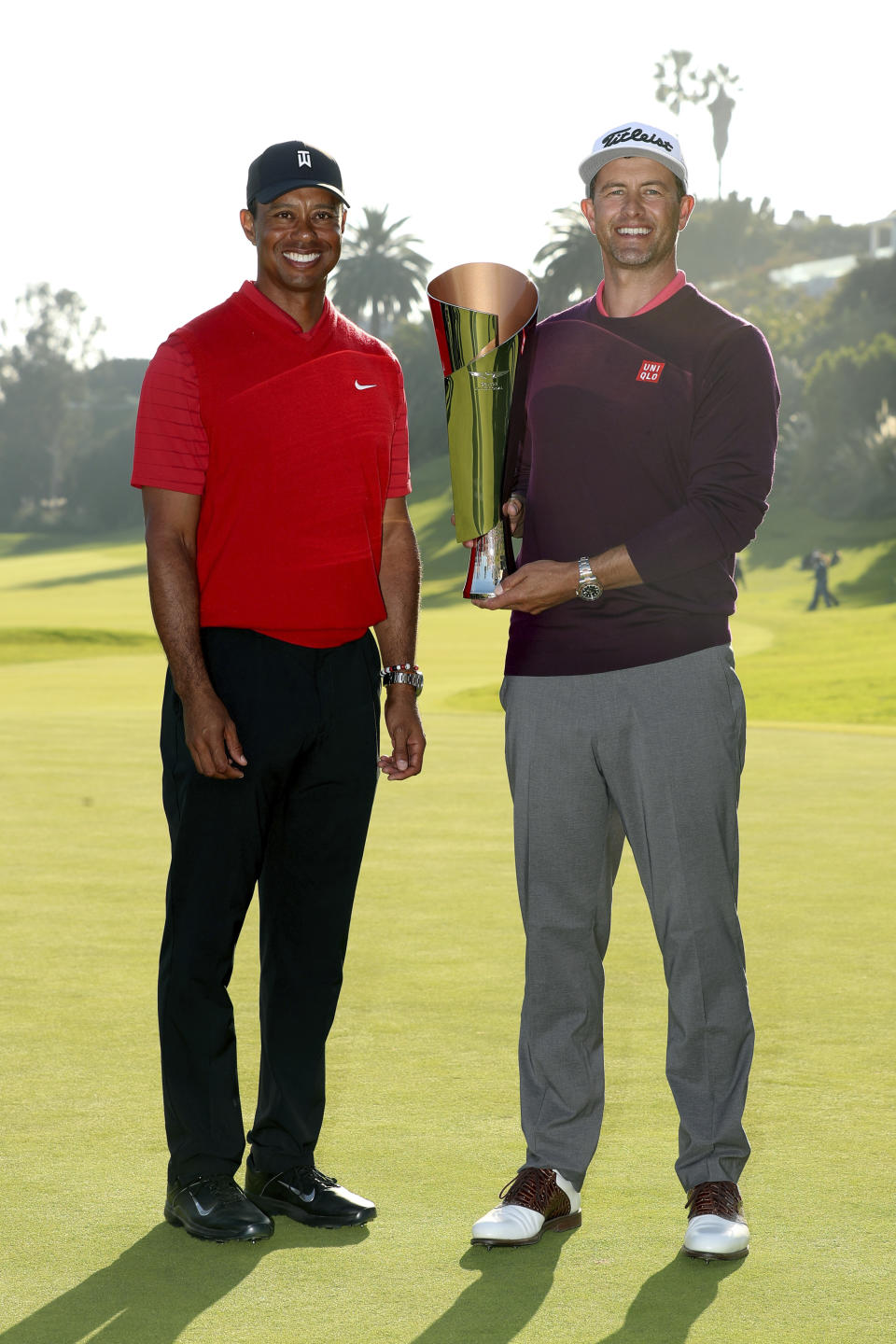Adam Scott, right, of Australia, poses with his trophy next to Tiger Woods on the 18th green after winning the Genesis Invitational golf tournament at Riviera Country Club, Sunday, Feb. 16, 2020, in the Pacific Palisades area of Los Angeles. (AP Photo/Ryan Kang)