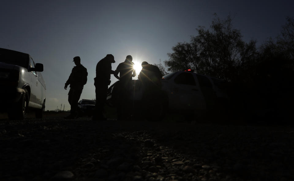 FILE - In this Nov. 6, 2019 file photo, Border Patrol agents apprehend a man thought to have entered the country illegally, near McAllen, Texas, along the U.S.-Mexico border. Immigration authorities are starting to ship asylum seekers who cross the border through Arizona to Texas, where they can be sent to Mexico to await their court hearings in the U.S. The government said its highly criticized program known colloquially as Remain in Mexico is now in effect all across the southwestern border. (AP Photo/Eric Gay, File)