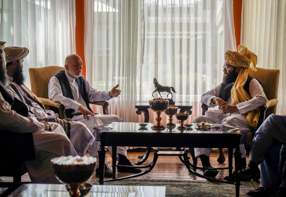 In this handout photograph released by the Taliban, former Afghan President Hamid Karzai, center left, senior Haqqani group leader Anas Haqqani, right, meet in Kabul, Afghanistan, Wednesday, Aug. 18, 2021. The meeting comes after the Taliban's lightning offensive saw the militants seize the capital, Kabul. (Taliban via AP)