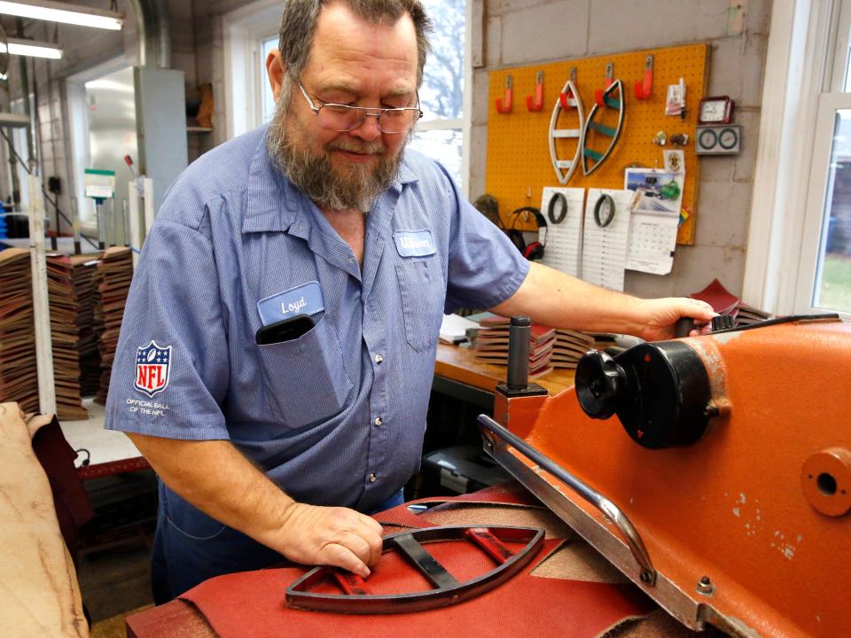 Wilson Sporting Goods worker Loyd Conley cuts leather from the Horween Leather Co. factory into quarter panels for an NFL football in Ada, Ohio.