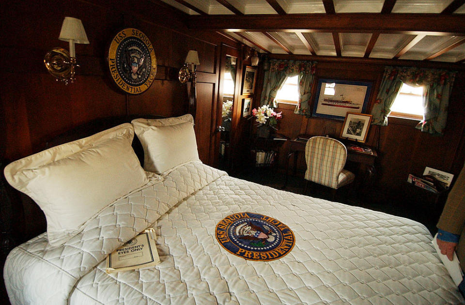 A large bed with the seal "USS Sequoia presidential yacht" on the comforter