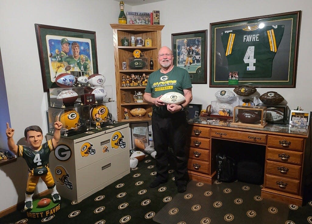 Dan "Bogie" Bogenschuetz stands in his home office amid Packers memorabilia. He's a big fan, and is a finalist to become a member of the Packers FAN Hall of Fame.
