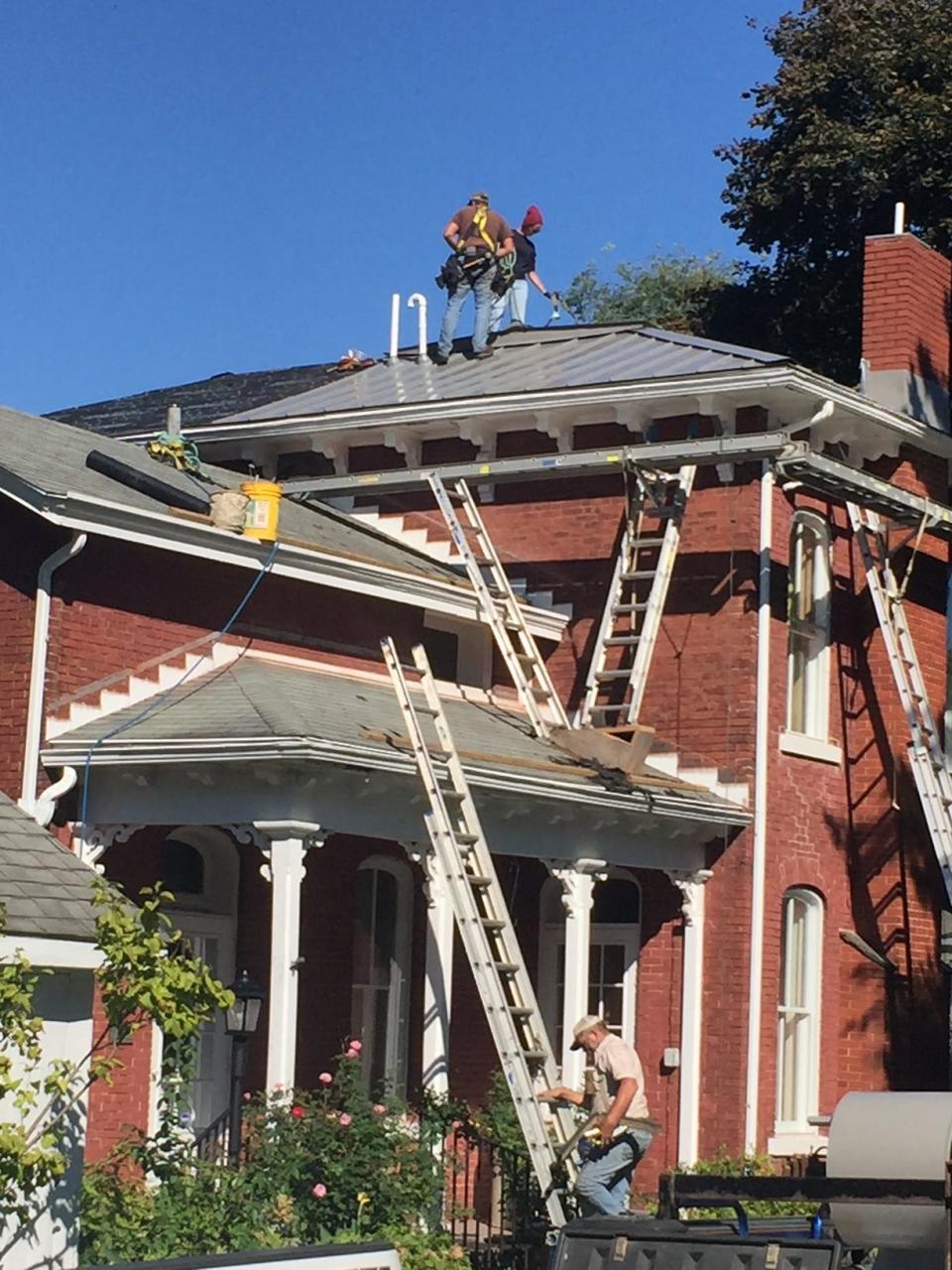 Workers place a new metal roof on the Mabel Hartzell Historical Home in 2018. The house, which was built in 1867 by Matthew Earley, is operated as a museum by the Alliance Historical Society.