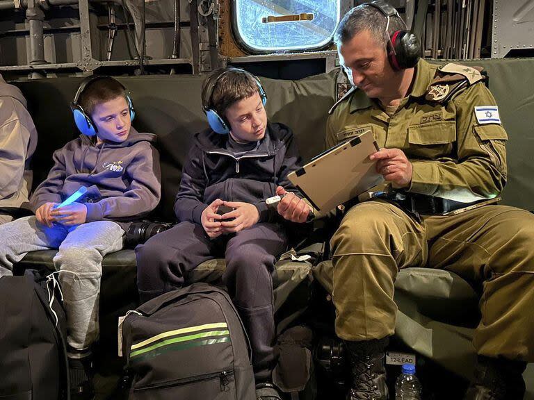 Esta fotografía proporcionada por las FDI el lunes 27 de noviembre de 2023 muestra a los rehenes israelíes liberados Tal Goldstein Almog, de 9 años y su hermano Gal, de 11 años, mientras regresan a Israel en un helicóptero.