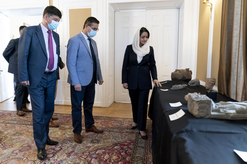 Afghan Ambassador to the U.S. Roya Rahmani, right, accompanied by embassy staff, speaks as she gives the Associated Press a tour at the Afghanistan Embassy in Washington, Wednesday, April 21, 2021, of looted and stolen Afghan religious relics and antiquities recovered by U.S. government authorities as part of a wider investigation into global trafficking in rare and ancient artifacts. (AP Photo/Andrew Harnik)