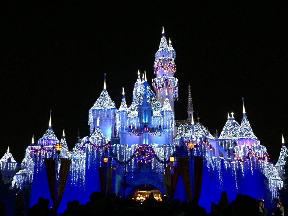 The Sleeping Beauty Castle at Disneyland lit up at night.