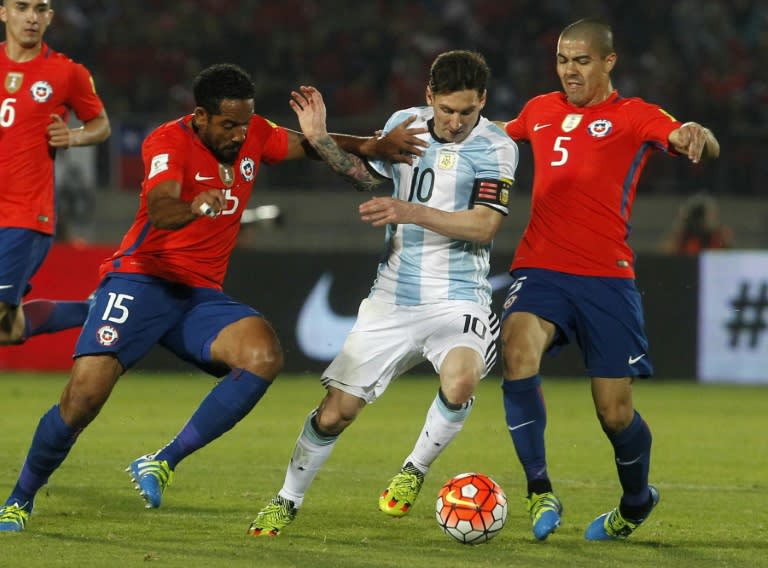 Chile's Jean Beausejour (L) and Francisco Silva (R) vie for the ball with Argentina's Lionel Messi during their 2018 FIFA World Cup South America qualifier in Santiago on March 24, 2016