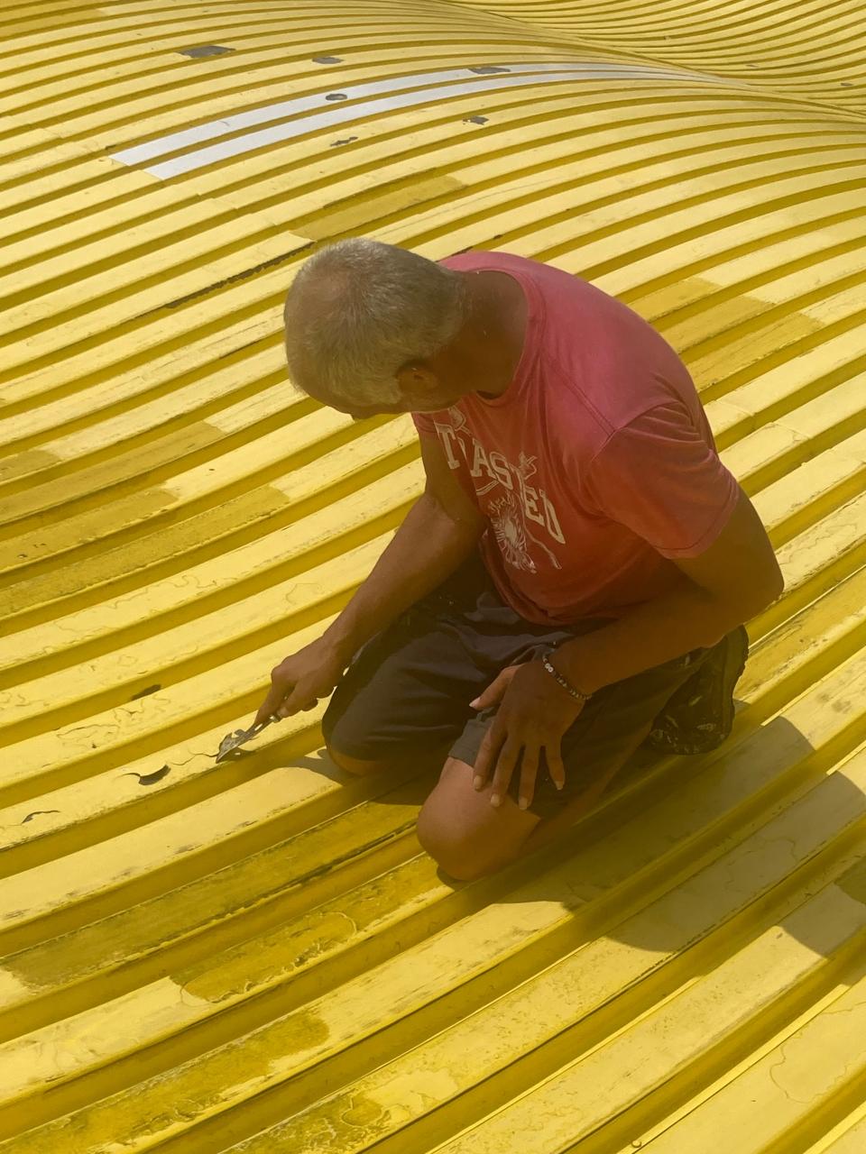 Patrick Peterson of Edwardsville scrapes paint on the Giant Slide on Thursday, Aug. 3, 2023. The slide is one of the fixtures of the Illinois State Fair, which runs Thursday through Aug. 20.