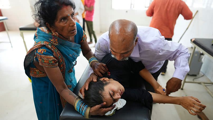 A father tries to calm his daughter suffering from a heat-related illness at a hospital in Ballia, Uttar Pradesh state, India, June 2023.