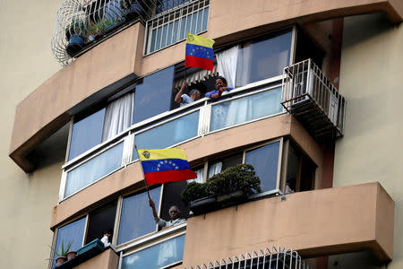 People wave the national flag from their windows during a protest against President Nicolas Maduro's government in Caracas, Venezuela, March 12, 2019. REUTERS/Carlos Garcia Rawlins