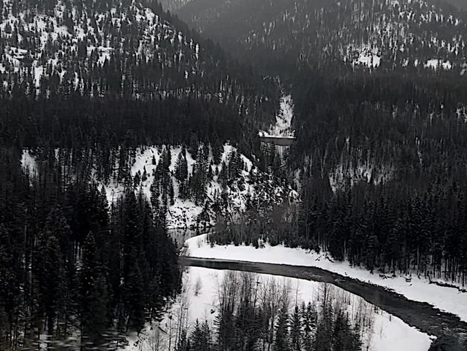 Mountains and a river outside Glacier National Park, as seen from an Amtrak train window.