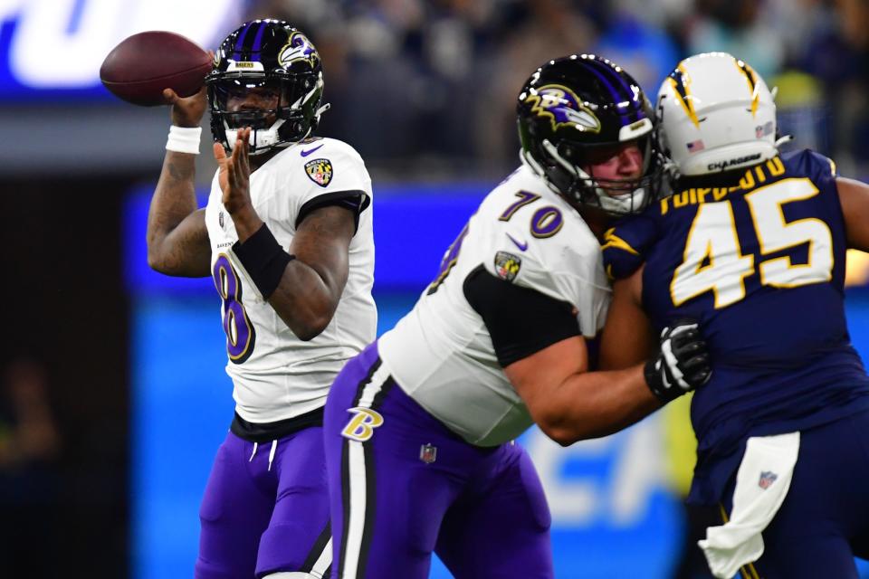 Nov 26, 2023; Inglewood, California, USA; Baltimore Ravens quarterback Lamar Jackson (8) throws as guard Kevin Zeitler (70) provides coverage against Los Angeles Chargers linebacker Tuli Tuipulotu (45) during the first half at SoFi Stadium. Mandatory Credit: Gary A. Vasquez-USA TODAY Sports