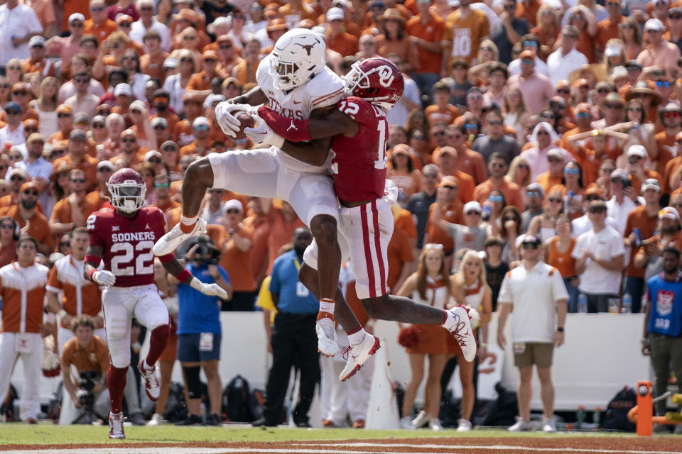 Texas tight end Ja'Tavion Sanders (0) hauls in a touchdown pass in front of Oklahoma defensive back Key Lawrence (12) during the second half of an NCAA college football game at the Cotton Bowl, Saturday, Oct. 8, 2022, in Dallas. Texas won 49-0. (AP Photo/Jeffrey McWhorter)