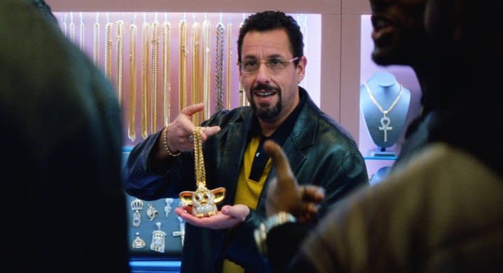 Adam Sandler holding a necklace in Uncut Gems.