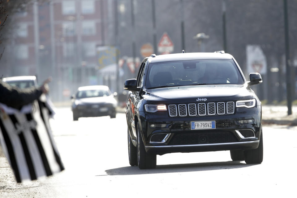 A fan waves a jersey as Juventus' Cristiano Ronaldo drives his car as he arrives for a training session at the Continassa Juventus center, in Turin, Italy, Friday, Jan. 11, 2019. Las Vegas police say investigators are asking Italian authorities to obtain a DNA sample from Cristiano Ronaldo in an ongoing rape investigation. (AP Photo/Luca Bruno)