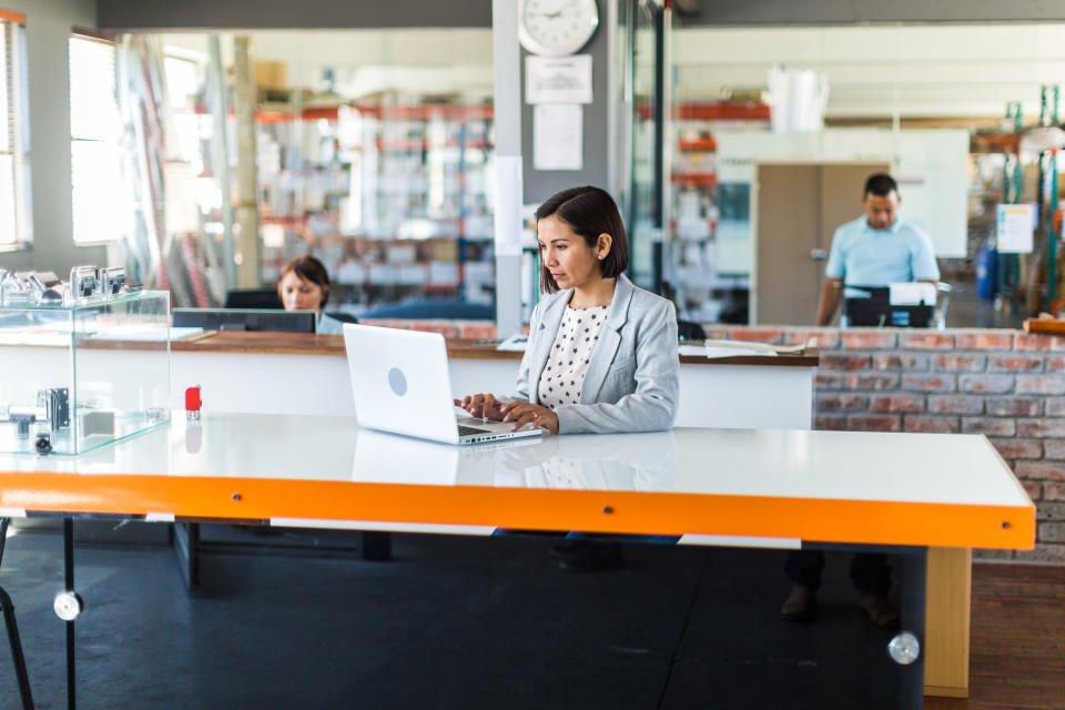 A woman sitting at a desk working on her laptop