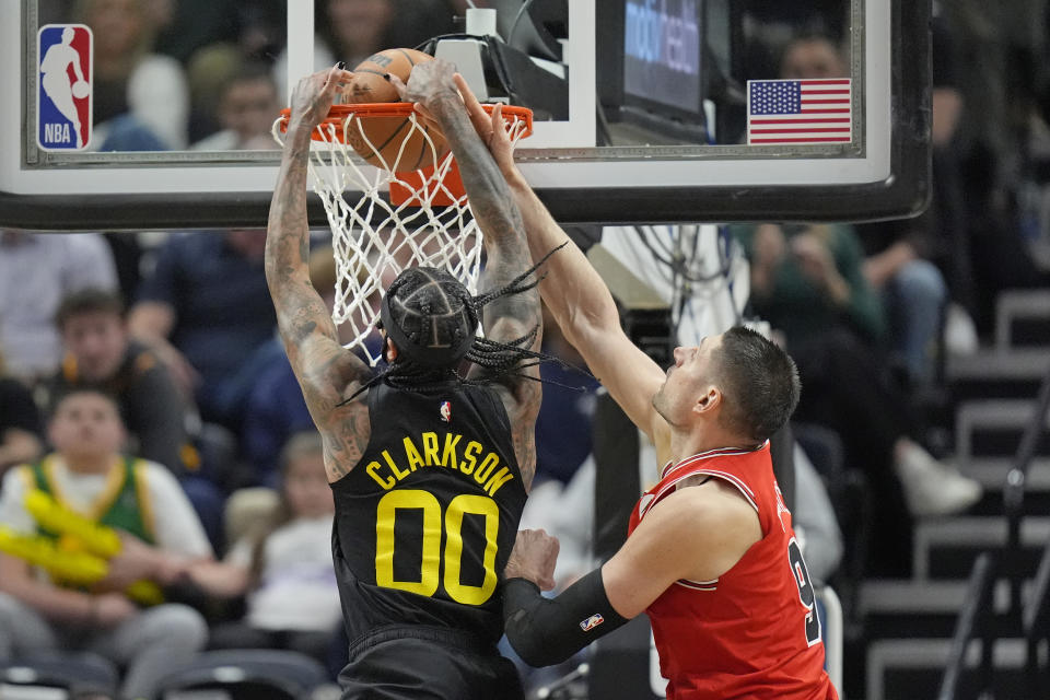 Utah Jazz guard Jordan Clarkson (00) dunks against Chicago Bulls center Nikola Vucevic, right, during the second half of an NBA basketball game Wednesday, March 6, 2024, in Salt Lake City. (AP Photo/Rick Bowmer)