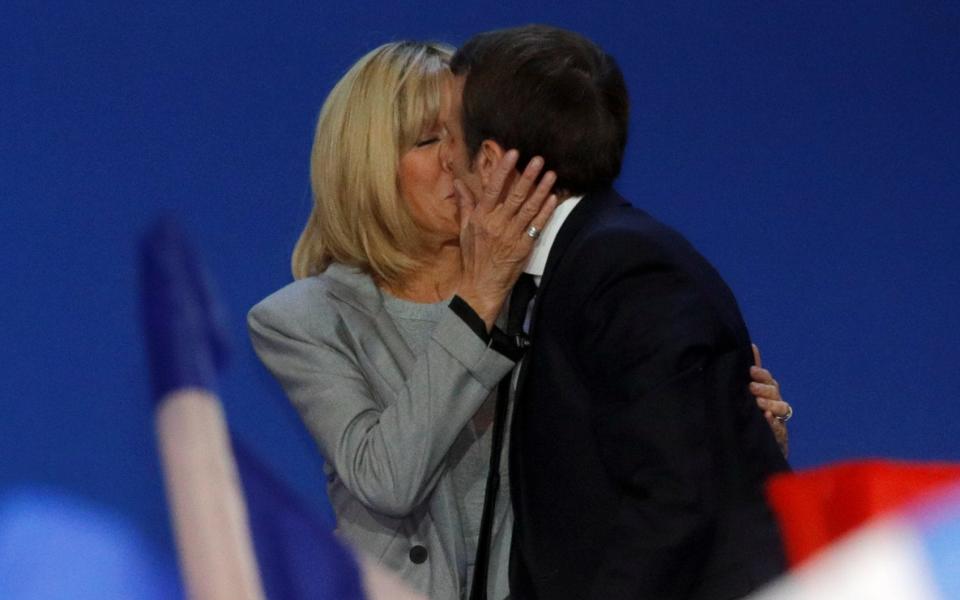 Emmanuel Macron kisses his wife Brigitte - Credit: Reuters