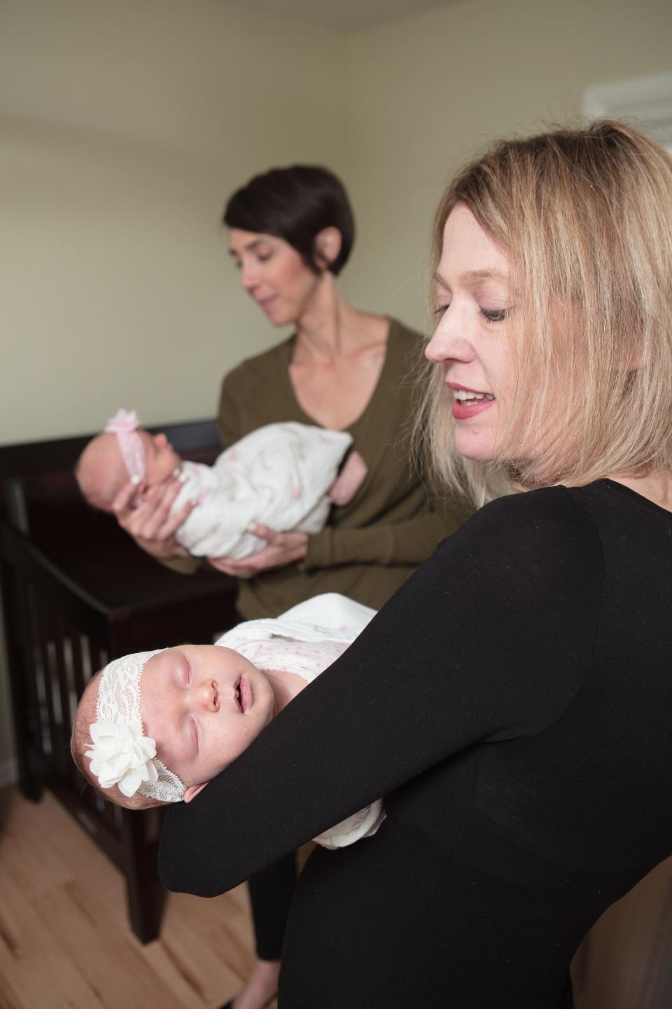 Gold Coast Doulas co-owners Kristin Revere (foreground) and Alyssa Veneklase (background) holding a client's twins.