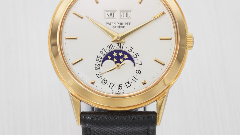 a gold watch with a black band