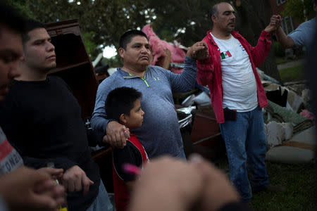 Samaritans hold hands in prayer after helping clearing debris from the house of a neighbor left flooded by Tropical Storm Harvey in Houston, Texas, U.S. September 4, 2017. REUTERS/Adrees Latif