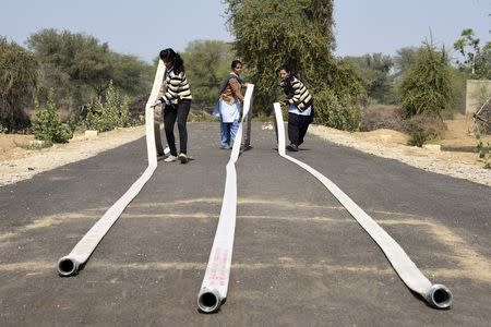 Students adjust hose pipes during a training session at a fire and safety college in Sikar district in Rajasthan February 9, 2015. REUTERS/Stringer