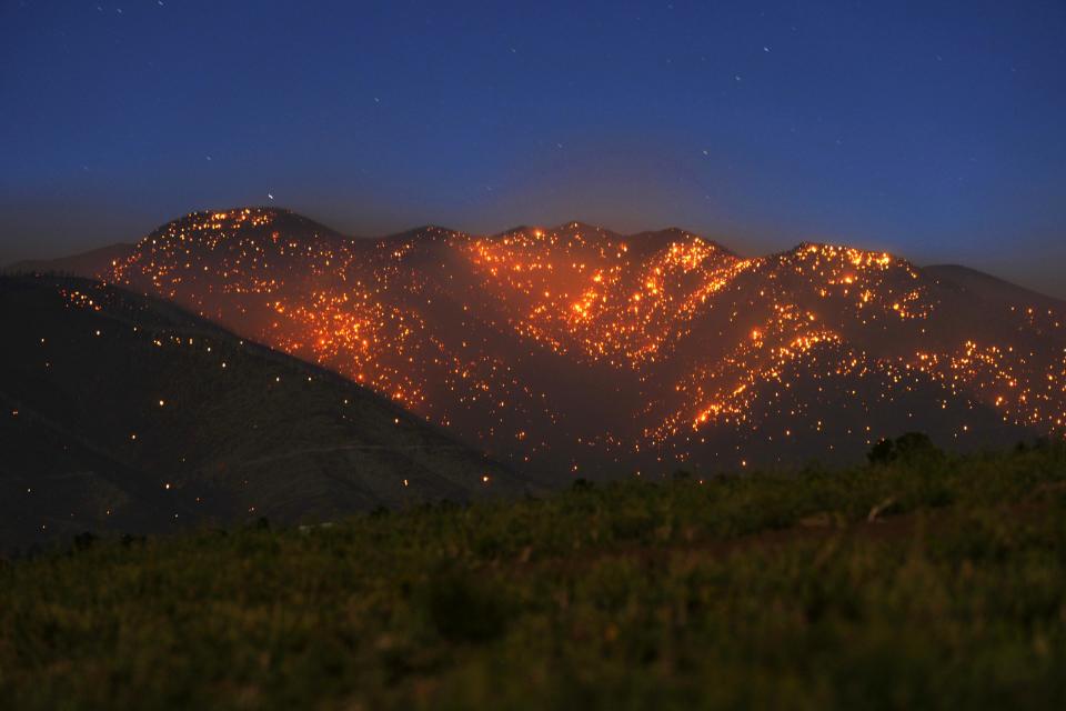The Pipeline Fire leaves the mountains northeast of the San Francisco Peaks glowing with thousands of spot fires on June 13, 2022 in Flagstaff.