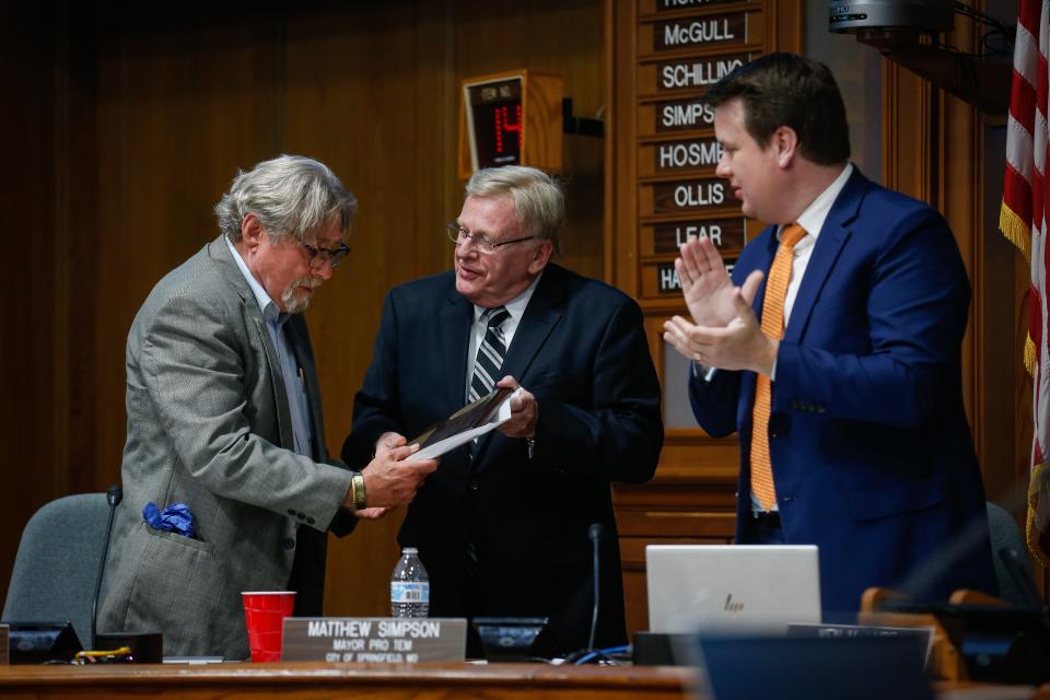 Former City Council Zone 3 Councilman Mike Schilling, left, accepts a plaque from Mayor Ken McClure, center, after his closing remarks during the Springfield City Council meeting on Monday, April 17, 2023.
