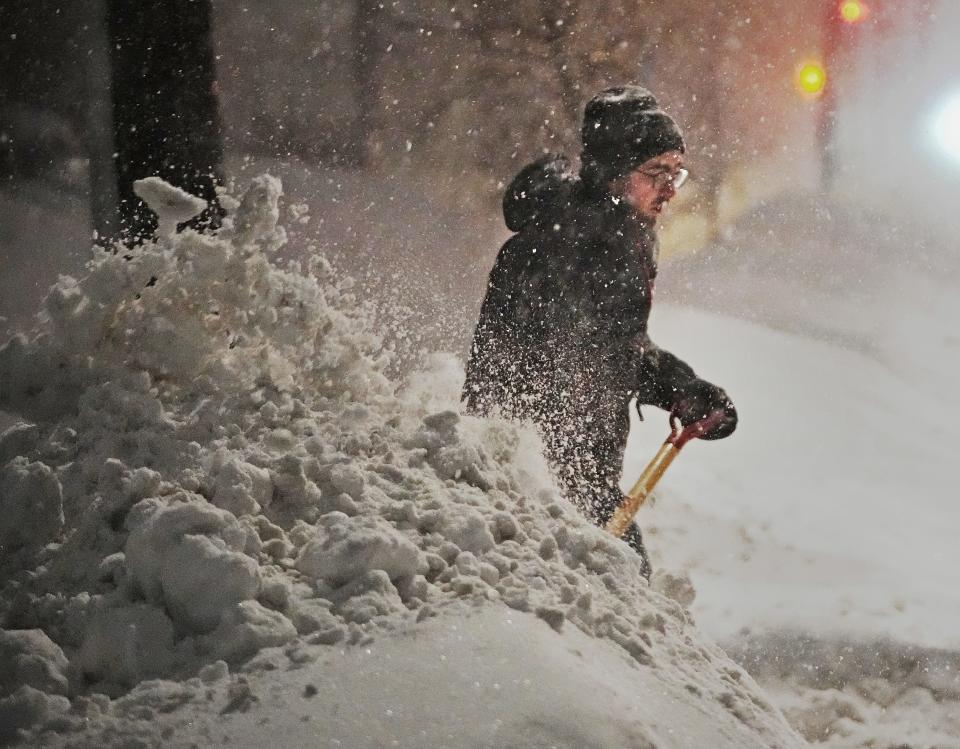 Brian Hedberg clears snow from the alleyway to try and get his car through a plowed snow bank on Feb. 23, 2023, in Minneapolis, Minn. Dangerous winter weather is ravaging the nation from California through the northern Plains.