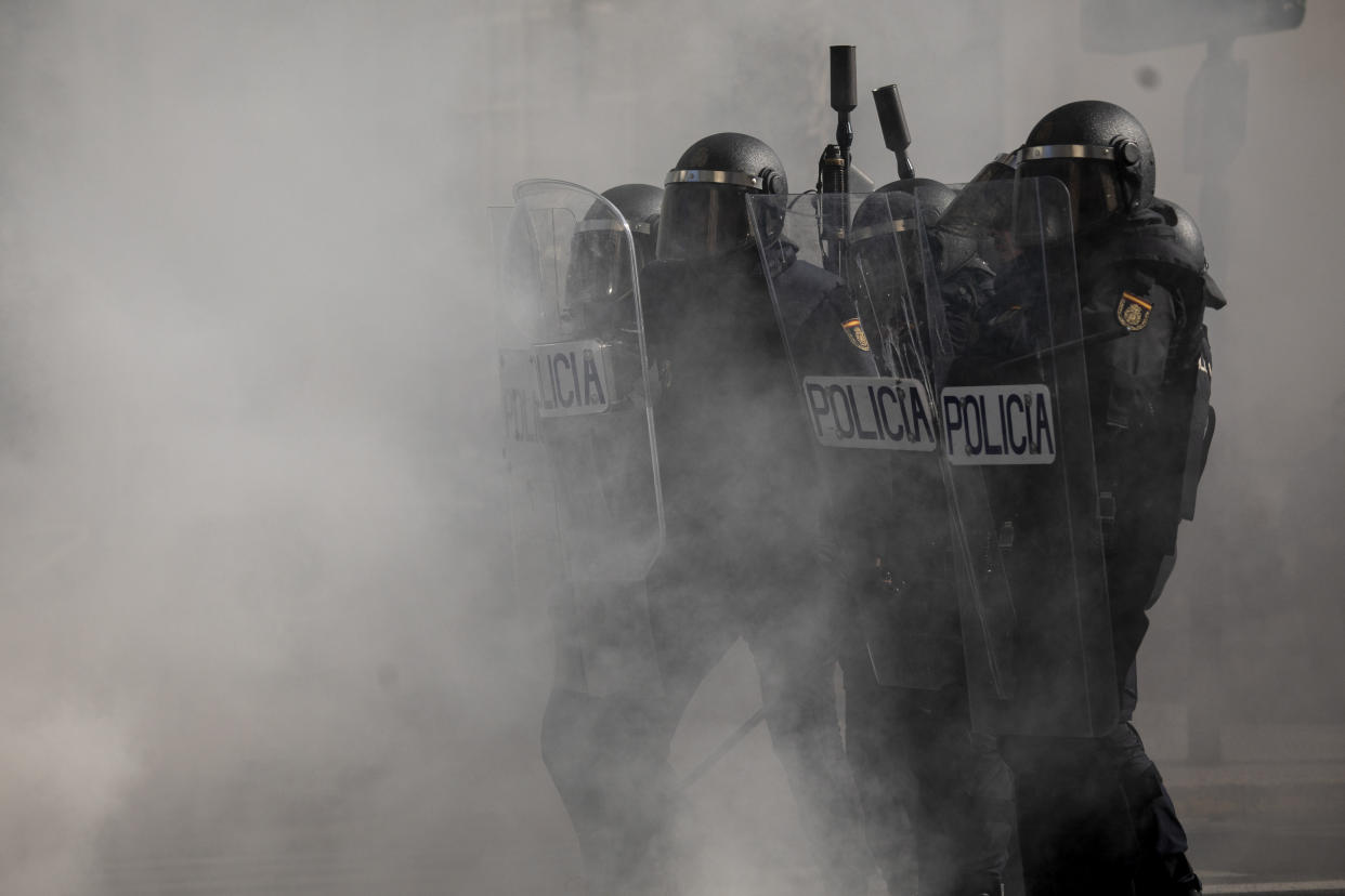 Anti-riot police take positions during clashes with protesters during a strike organized by metal workers in Cadiz, southern Spain, Tuesday, Nov. 23, 2021. (AP Photo/Javier Fergo)