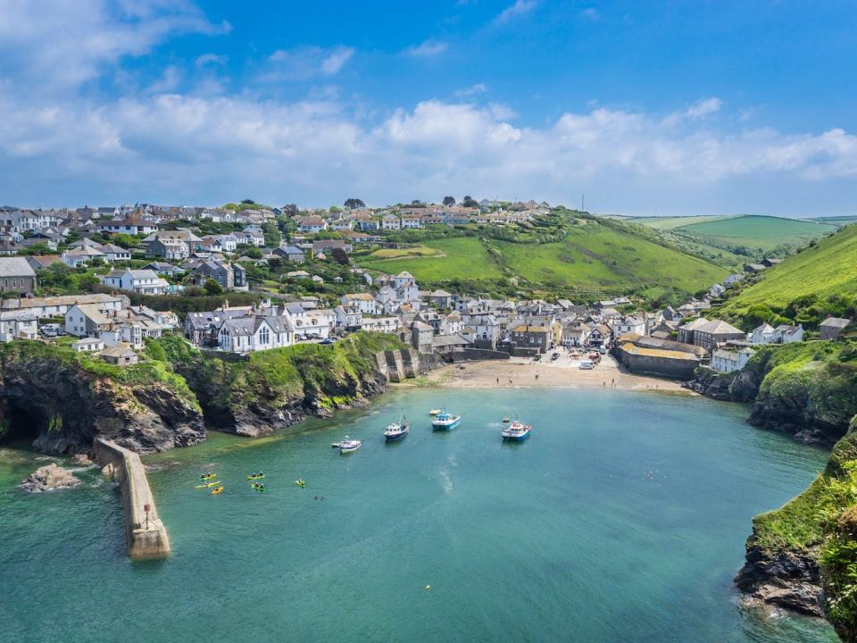 The Port of Issac in Cornwall UK with ocean and rocky cliff-sides.