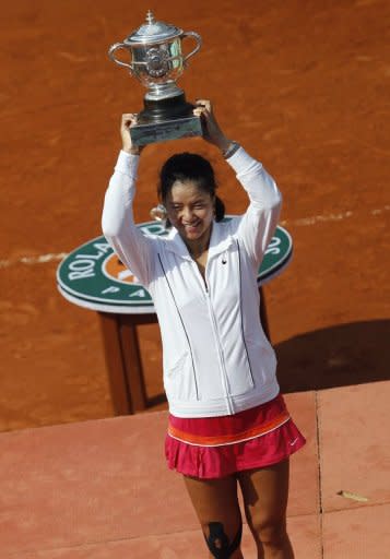 China's Li Na poses with the trophy after defeating Italy's Francesca Schiavone in their Women's final of the French Open tennis championship at the Roland Garros stadium, in Paris, June 2011. Her straight sets demolition of defending champion Schiavone made her the first Asian player to win a Grand Slam singles title