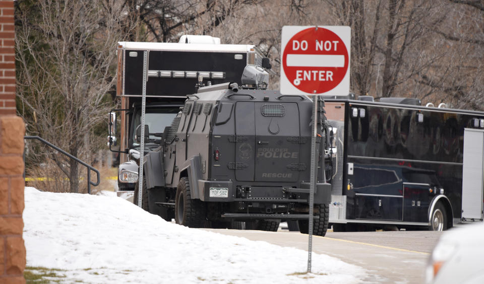 Police vehicles sit in front of University Hill Elementary School across from the campus of the University of Colorado after a man accused of making mass shooting threats against the college as well as the University of California, Los Angeles, was arrested Tuesday, Feb. 1, 2022, in Boulder, Colo. The police operation caused the evacuation of the elementary school and shelter-in-place orders for nearby residents on Boulder's University Hill. (AP Photo/David Zalubowski)