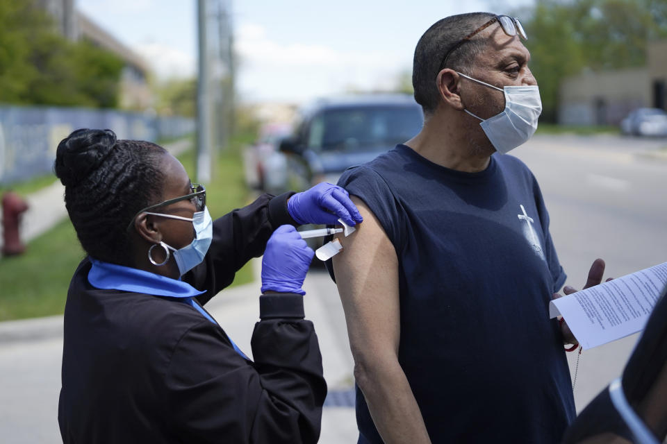 Registered nurse Precious McCormick administers a syringe of Moderna COVID-19 vaccine to Apolonio Mata in Detroit, Wednesday, May 12, 2021. In three weeks, more than 40 people have received vaccinations through the program to reach people who normally have little to no access to churches, community centers or other places where vaccines are being given. Mobile care teams consisting of two nurses and a peer support specialist accompany The Salvation Army's Bed & Bread trucks as they cruise Detroit, which lags far behind the state and nearby communities in percentage of people vaccinated. (AP Photo/Paul Sancya)