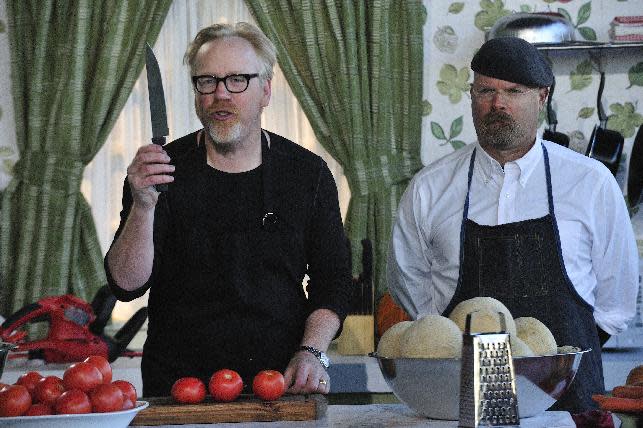 In this undated image released by Discovery Channel, hosts Adam Savage, left, Jamie Hyneman appear in a mock kitchen to introduce teams on Discovery Channel's "Unchained Reaction." for the episode's builds: Celebrating Tools! They show how a range of household tools can be used to great effect in the kitchen. In each episode, two five-person teams of engineers, designers and the like are given five days and a warehouse full of tools and materials to create a contraption based on a simple theme, such as "light vs. heavy" or "fire and ice." Then, Hyneman, Savage and a guest judge decide which one is the most inventive. The show premieres March 18, at 10 p.m. EST on Discovery. (AP Photo/Discovery Channel, Rahoul Ghose) (AP Photo/Discovery Channel)