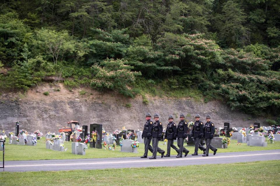 Kentucky state troopers walk out of the cemetery following the ceremony for Floyd County Deputy William Petry in Prestonsburg, Ky., Tuesday, July 5, 2022.