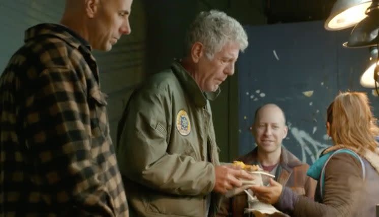 Anthony Bourdain with a plate of&nbsp;morcilla and potato cakes in Corona, Queens. (Photo: CNN)