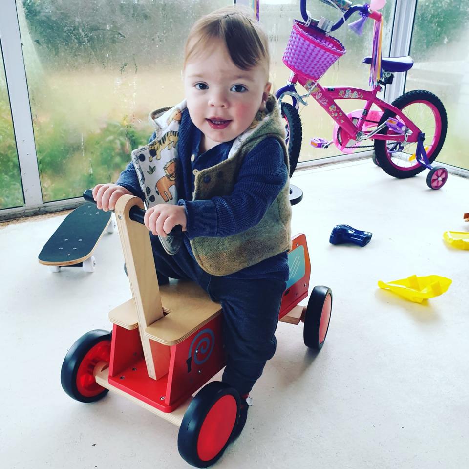 The 18-month-old boy is seen here riding on a toy bike.