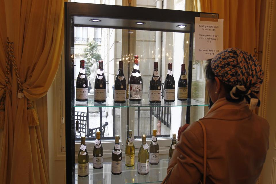 Visitors take a look at bottles of wine displayed for auction at the Crillon Hotel in Paris, Monday April 15, 2013. Located Place de la Concorde, the Crillon hotel will put most of its furniture and some of his fine wines under the hammer next week, before a two-year restauration.(AP Photo/Remy de la Mauviniere)